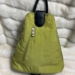 Baggallini green fabric small backpack/sling back with black straps and trims.